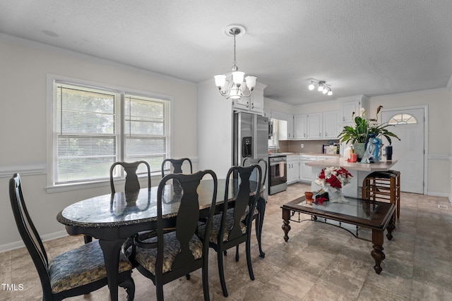 dining space with a textured ceiling, a chandelier, and ornamental molding