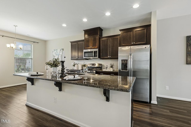 810 Richmont Grove Ln, Apex, NC 27523 - kitchen featuring stainless steel appliances, dark wood-style floors, a kitchen breakfast bar, dark brown cabinetry, and recessed lighting