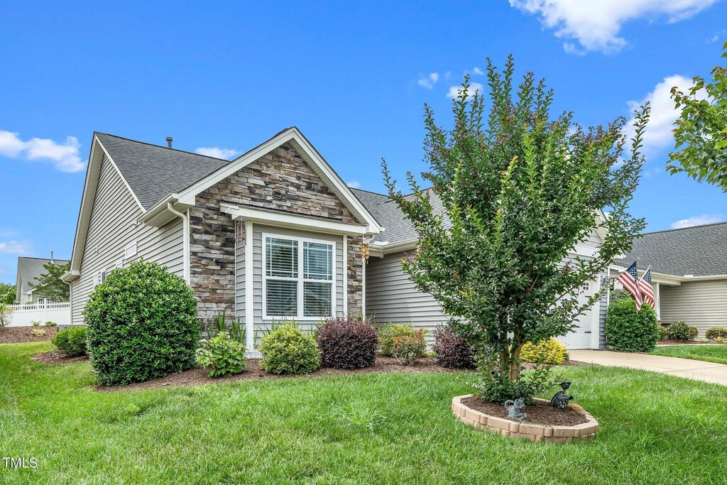 2033 Buck Corner Ln, Fuquay Varina, NC 27526 - view of front of house with stone siding, an attached garage, a front yard, and concrete driveway