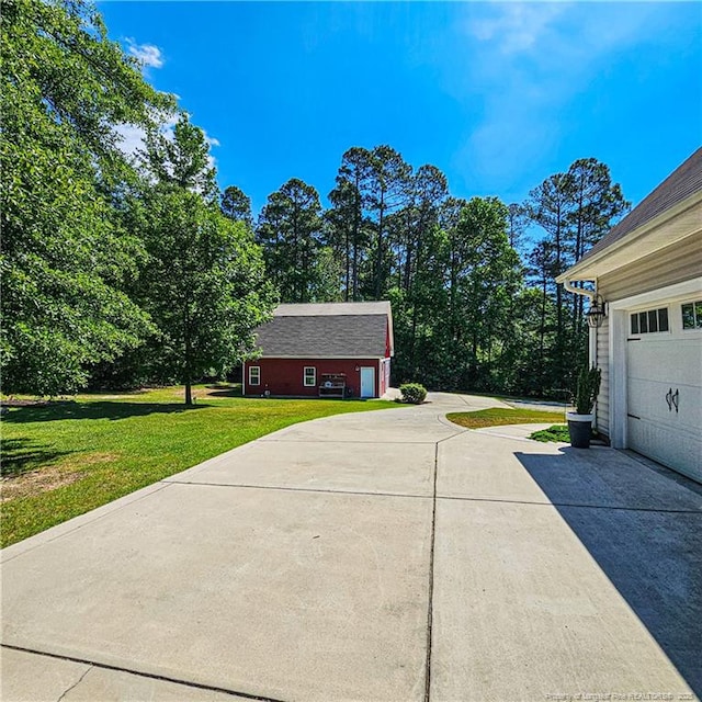 1303 Palestine Rd, Linden, NC 28356 - view of side of property featuring concrete driveway, a lawn, and a garage