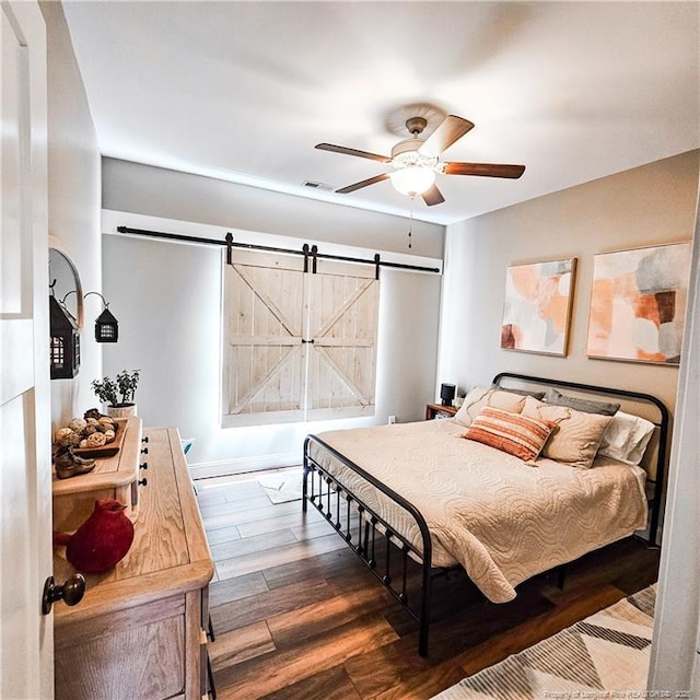 1303 Palestine Rd, Linden, NC 28356 - bedroom with a barn door, wood finished floors, and ceiling fan