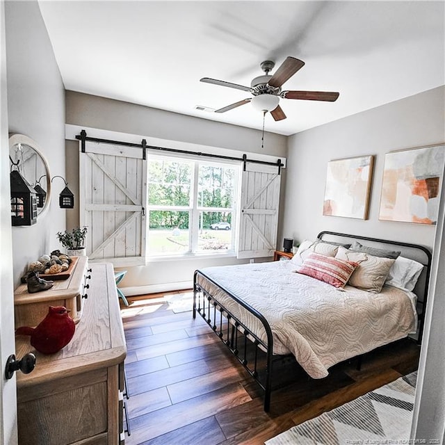 1303 Palestine Rd, Linden, NC 28356 - bedroom with a barn door, wood finished floors, and a ceiling fan