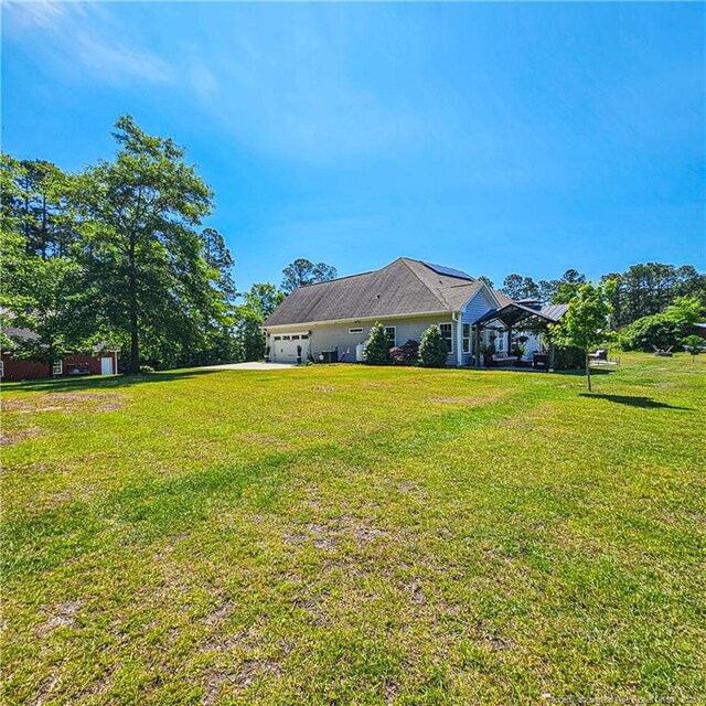 1303 Palestine Rd, Linden, NC 28356 - view of green lawn featuring an attached garage and driveway