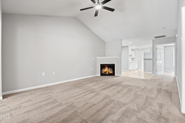 11220 Avocet Ln Unit 104, Raleigh, NC 27617 - unfurnished living room with light colored carpet, ceiling fan, lofted ceiling, a warm lit fireplace, and baseboards