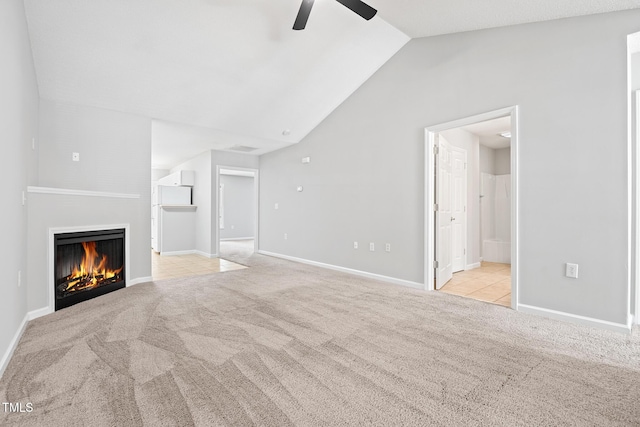 11220 Avocet Ln Unit 104, Raleigh, NC 27617 - unfurnished living room with ceiling fan, carpet floors, a warm lit fireplace, lofted ceiling, and baseboards