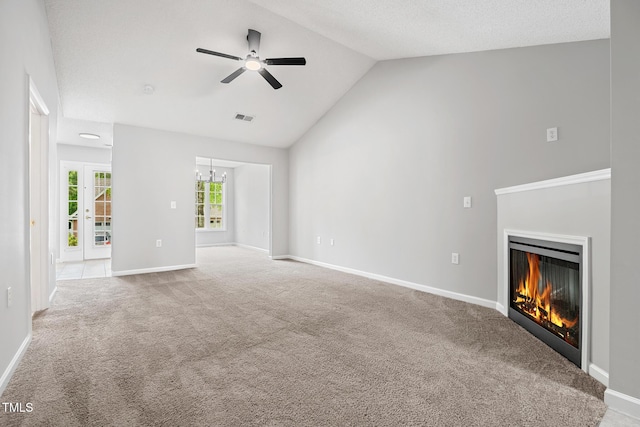 11220 Avocet Ln Unit 104, Raleigh, NC 27617 - unfurnished living room featuring ceiling fan, carpet floors, a glass covered fireplace, high vaulted ceiling, and a chandelier