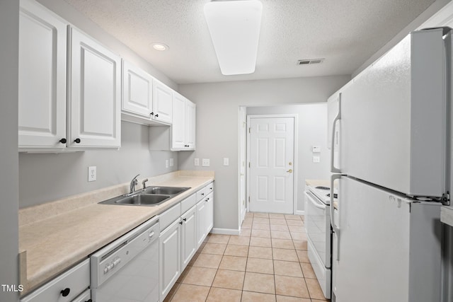 11220 Avocet Ln Unit 104, Raleigh, NC 27617 - kitchen featuring white appliances, a sink, a textured ceiling, white cabinets, and light countertops