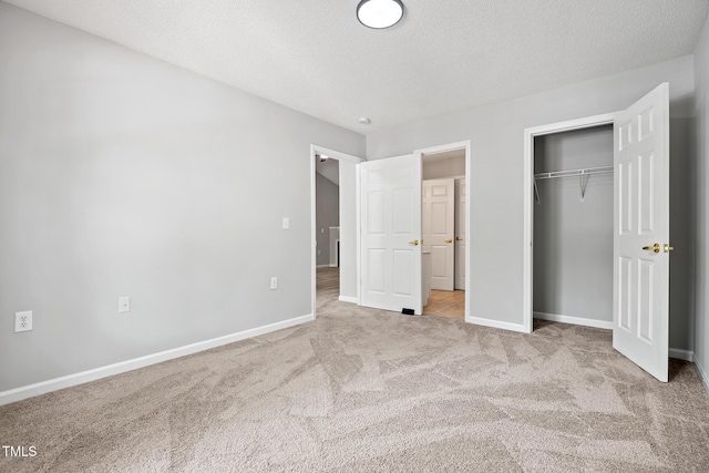 11220 Avocet Ln Unit 104, Raleigh, NC 27617 - unfurnished bedroom featuring carpet, baseboards, a closet, and a textured ceiling