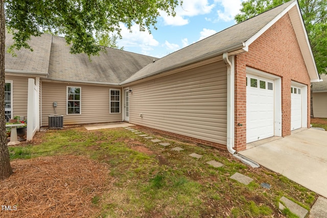11220 Avocet Ln Unit 104, Raleigh, NC 27617 - rear view of house featuring brick siding, a garage, and central AC