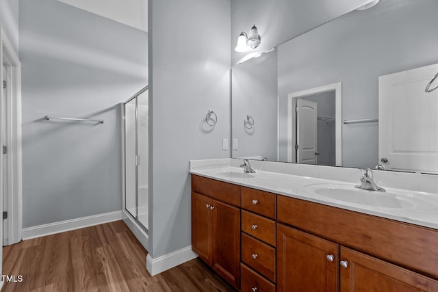 39 Mcguire Ln, Clayton, NC 27527 - bathroom featuring wood finished floors, double vanity, a stall shower, baseboards, and a spacious closet