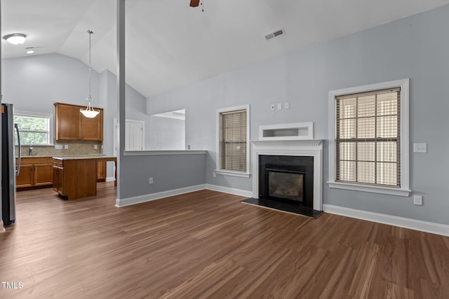 39 Mcguire Ln, Clayton, NC 27527 - unfurnished living room with high vaulted ceiling, dark wood finished floors, baseboards, ceiling fan, and a glass covered fireplace