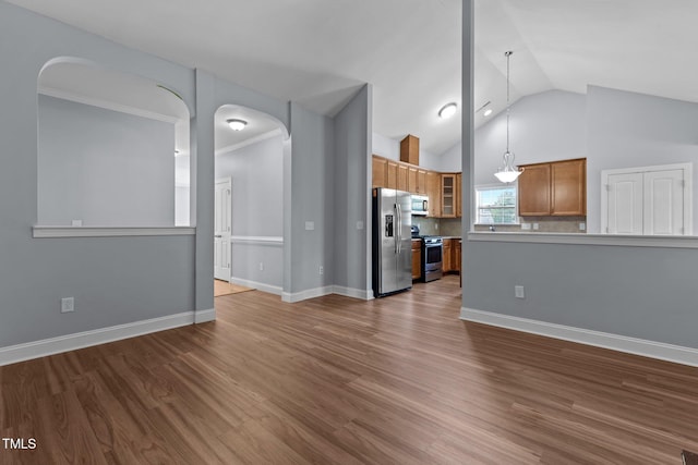 39 Mcguire Ln, Clayton, NC 27527 - unfurnished living room featuring arched walkways, lofted ceiling, dark wood-style floors, and baseboards