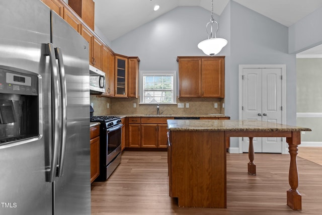 39 Mcguire Ln, Clayton, NC 27527 - kitchen featuring stainless steel appliances, a sink, a breakfast bar area, light wood-type flooring, and brown cabinets