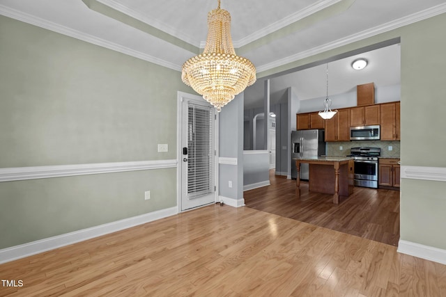 39 Mcguire Ln, Clayton, NC 27527 - kitchen featuring appliances with stainless steel finishes, a chandelier, a kitchen breakfast bar, brown cabinetry, and dark wood finished floors