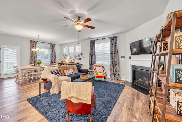 1096 Aberlour Ln, Burlington, NC 27215 - living room featuring a fireplace with flush hearth, wood finished floors, a ceiling fan, and a chandelier