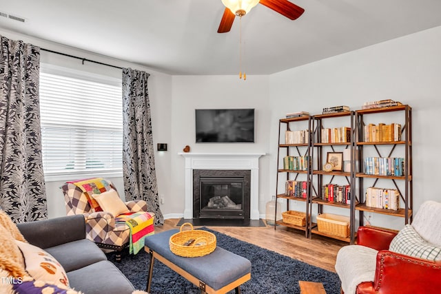1096 Aberlour Ln, Burlington, NC 27215 - living room with wood finished floors, ceiling fan, a fireplace with flush hearth, and baseboards