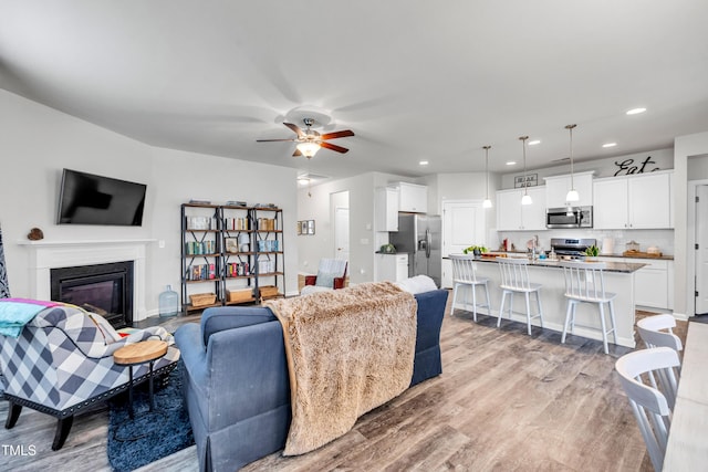 1096 Aberlour Ln, Burlington, NC 27215 - living area featuring light wood-style floors, recessed lighting, a ceiling fan, and a glass covered fireplace