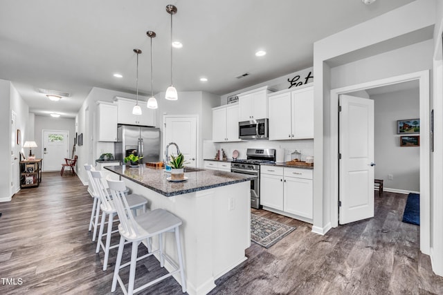 1096 Aberlour Ln, Burlington, NC 27215 - kitchen with appliances with stainless steel finishes, a sink, dark wood-style floors, a kitchen breakfast bar, and white cabinetry