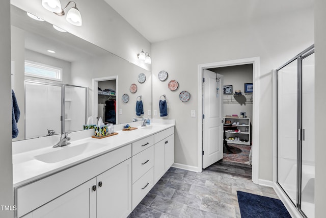 1096 Aberlour Ln, Burlington, NC 27215 - bathroom featuring a shower stall, baseboards, a spacious closet, and double vanity