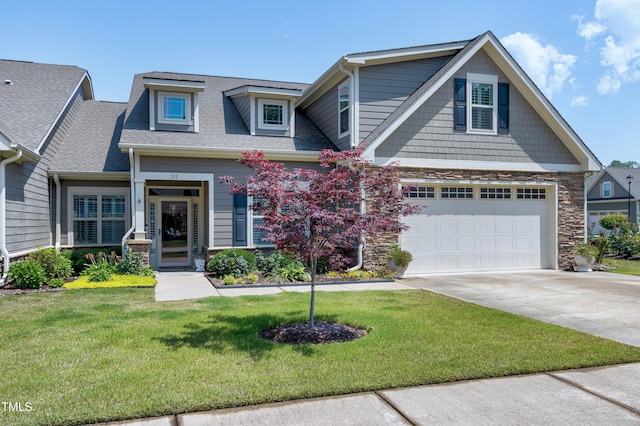view of front of property featuring a garage, concrete driveway, a front lawn, and stone siding