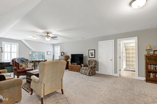 living room featuring light colored carpet, ceiling fan, and baseboards