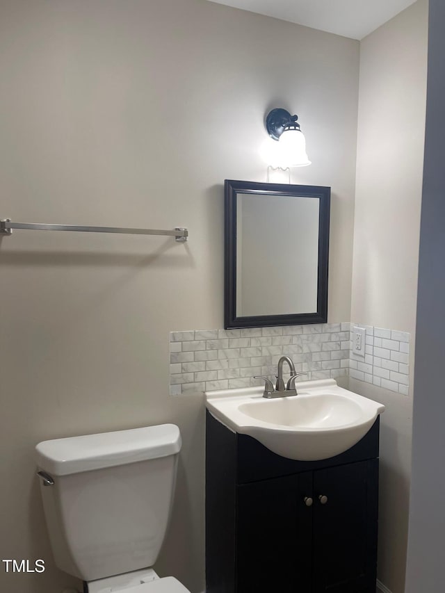 bathroom featuring backsplash, toilet, and vanity