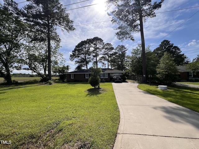 single story home featuring driveway, a front lawn, and an attached carport