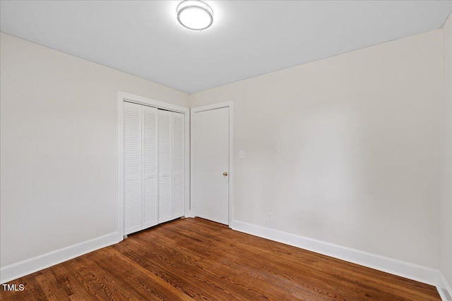 5345 Lamm Rd, Wilson, NC 27893 - unfurnished bedroom with baseboards, dark wood-style flooring, and a closet