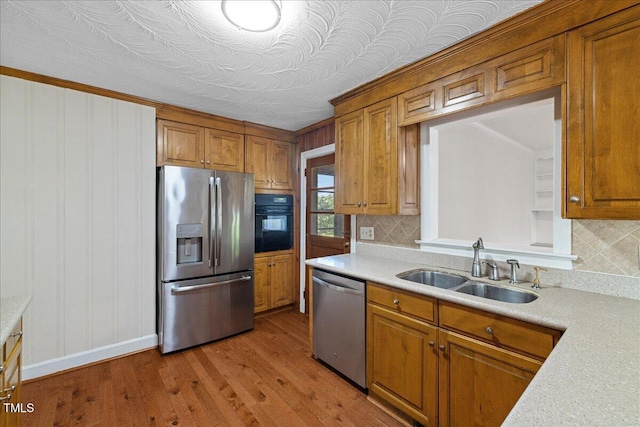 5345 Lamm Rd, Wilson, NC 27893 - kitchen featuring stainless steel appliances, brown cabinets, a sink, and light countertops