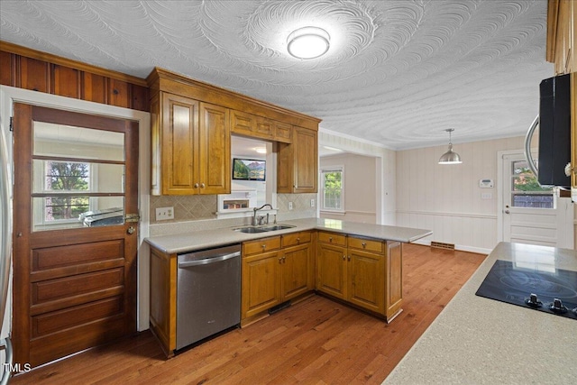 5345 Lamm Rd, Wilson, NC 27893 - kitchen with stainless steel appliances, a sink, light countertops, light wood-style flooring, and a peninsula