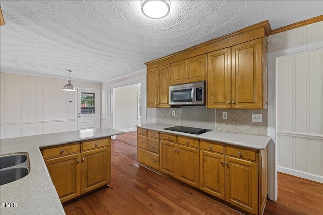5345 Lamm Rd, Wilson, NC 27893 - kitchen with stainless steel microwave, brown cabinets, light countertops, dark wood-type flooring, and a decorative wall