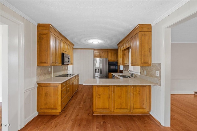 5345 Lamm Rd, Wilson, NC 27893 - kitchen with black appliances, a sink, wood finished floors, tasteful backsplash, and brown cabinets