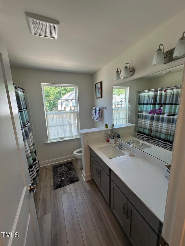 99 Still Hand Dr, Clayton, NC 27527 - bathroom with toilet, vanity, healthy amount of natural light, and wood finished floors