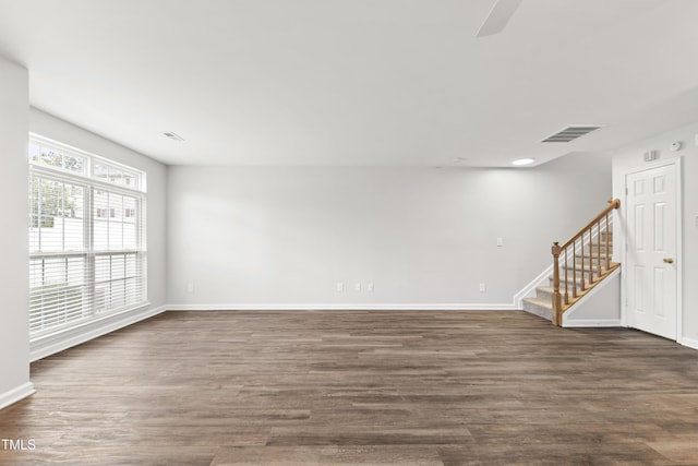 8610 Neuse Landing Ln Unit 103, Raleigh, NC 27616 - unfurnished room featuring stairs, baseboards, dark wood-style flooring, and ceiling fan