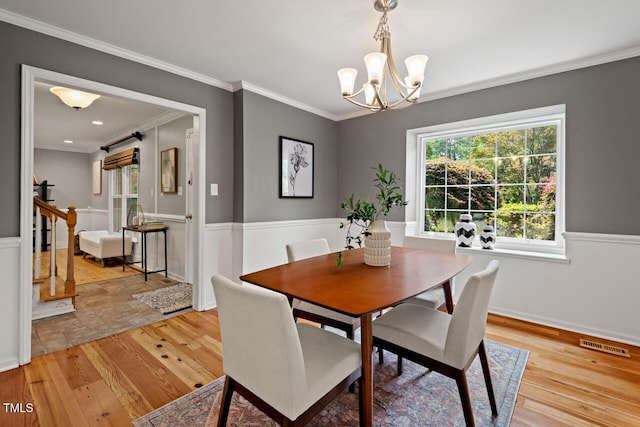 6304 Ansley Ln, Raleigh, NC 27612 - dining space with light wood-type flooring, crown molding, a chandelier, and baseboards