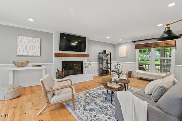 6304 Ansley Ln, Raleigh, NC 27612 - living area with ornamental molding, recessed lighting, a wainscoted wall, wood finished floors, and a fireplace