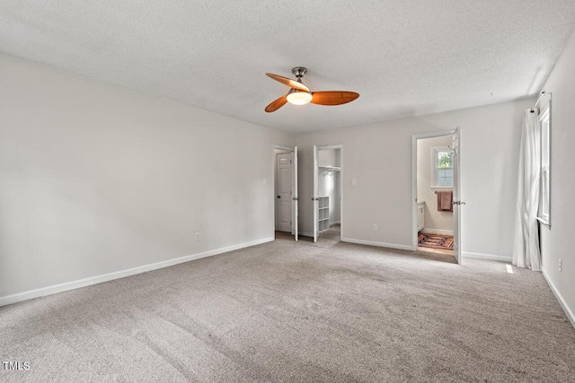 6304 Ansley Ln, Raleigh, NC 27612 - unfurnished bedroom featuring carpet flooring, a textured ceiling, baseboards, connected bathroom, and a spacious closet