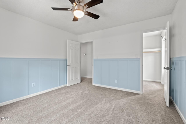 6304 Ansley Ln, Raleigh, NC 27612 - unfurnished bedroom with wainscoting, a decorative wall, carpet flooring, and ceiling fan