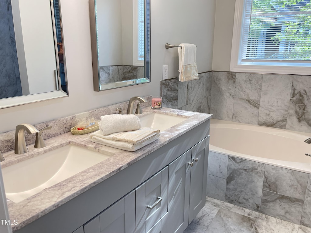 full bath featuring double vanity and a bath