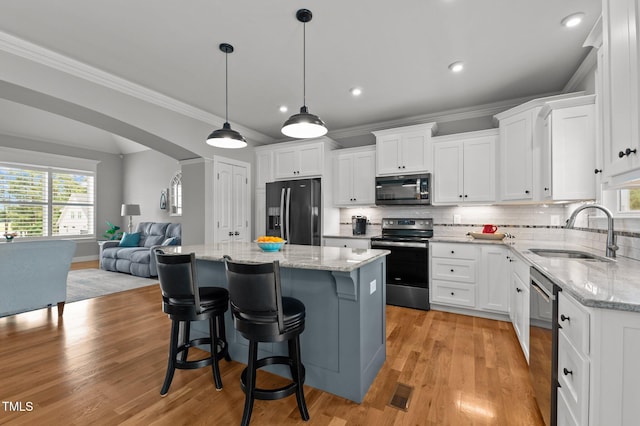 4564 Ashtons Way, Franklinton, NC 27525 - kitchen with stainless steel appliances, a sink, open floor plan, a center island, and white cabinetry
