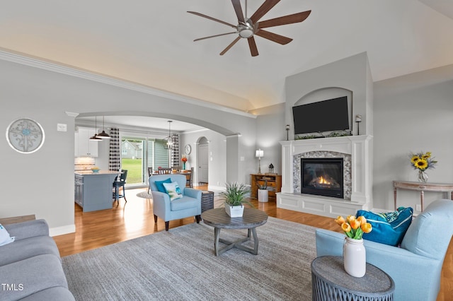 4564 Ashtons Way, Franklinton, NC 27525 - living room with ceiling fan, arched walkways, light wood-type flooring, lofted ceiling, and a glass covered fireplace