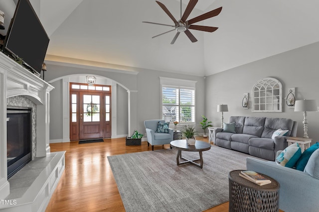 4564 Ashtons Way, Franklinton, NC 27525 - living area featuring a ceiling fan, arched walkways, light wood finished floors, a tile fireplace, and high vaulted ceiling