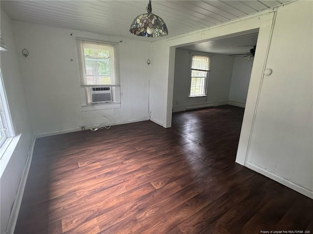 spare room featuring dark wood-style floors, baseboards, and cooling unit