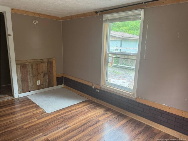 spare room featuring a textured ceiling and wood finished floors