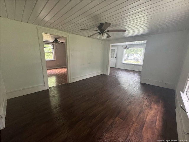 empty room featuring a ceiling fan, dark wood-type flooring, baseboards, and wood ceiling