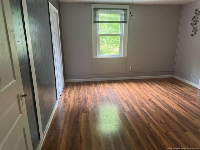 unfurnished bedroom featuring wood finished floors and baseboards
