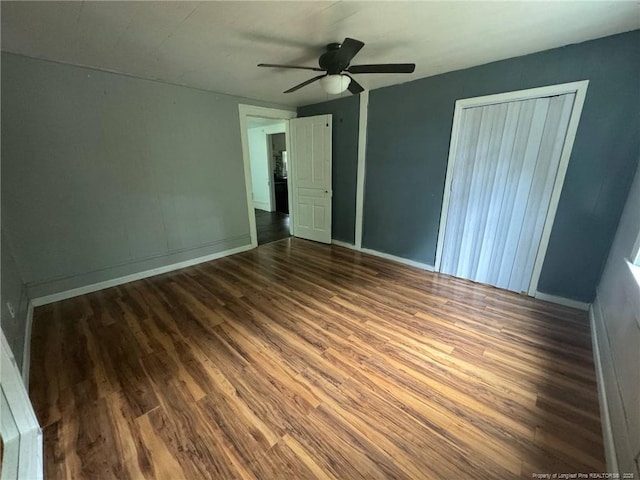 unfurnished bedroom with wood finished floors, baseboards, ceiling fan, and a closet