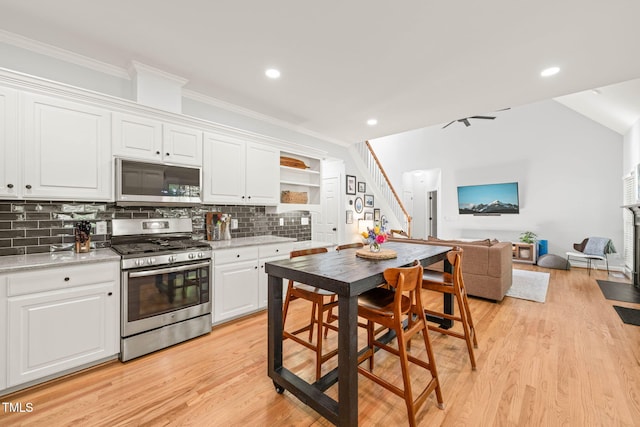2408 Fordcrest Dr, Apex, NC 27502 - kitchen with appliances with stainless steel finishes, tasteful backsplash, white cabinets, crown molding, and light wood finished floors
