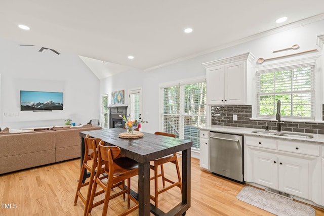 2408 Fordcrest Dr, Apex, NC 27502 - kitchen featuring dishwasher, a sink, healthy amount of natural light, a fireplace, and crown molding