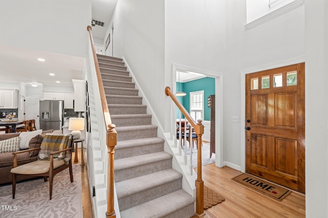 2408 Fordcrest Dr, Apex, NC 27502 - entrance foyer featuring a high ceiling, stairs, light wood finished floors, healthy amount of natural light, and recessed lighting